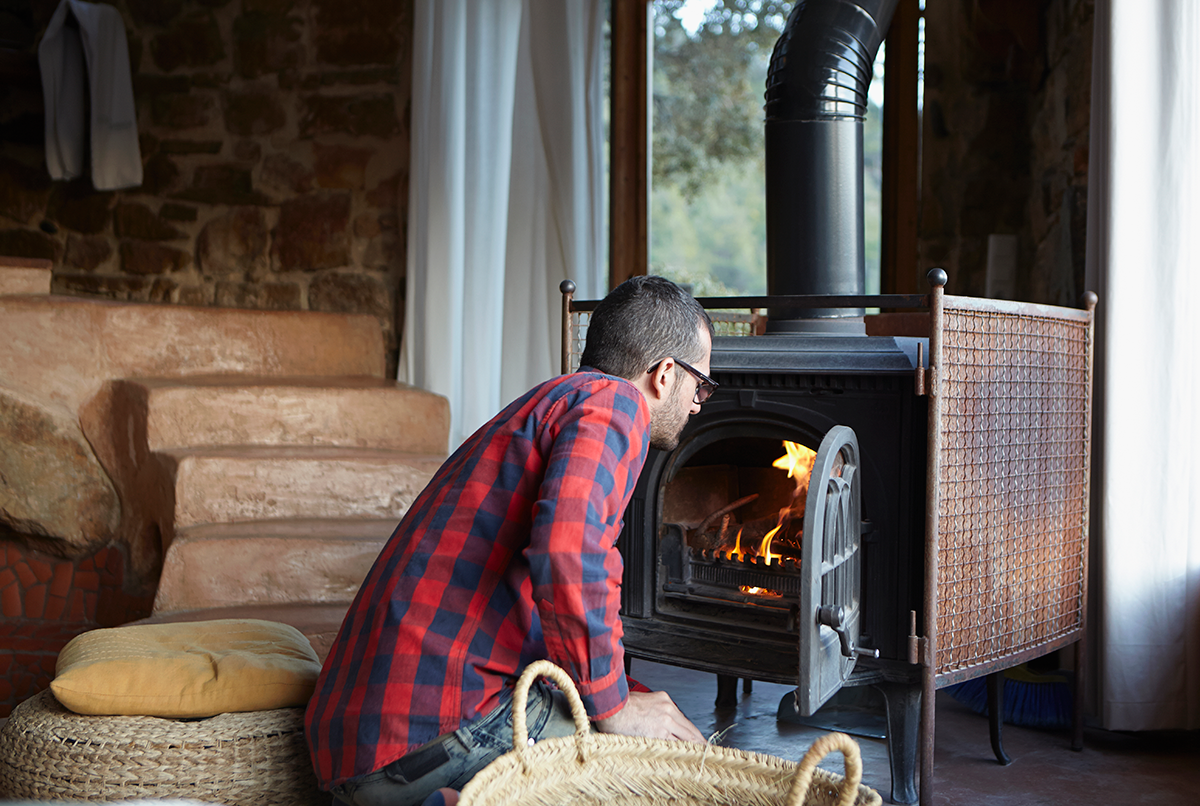 Man checking wood burning stove